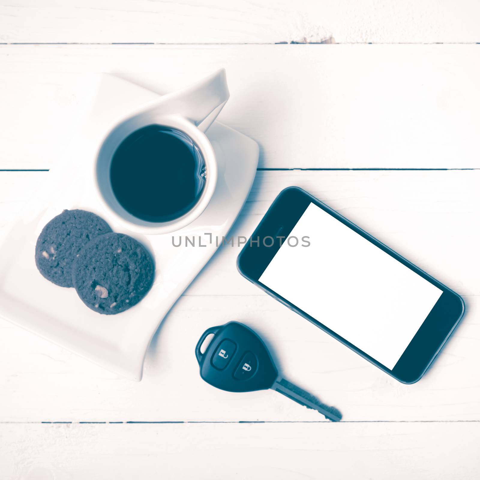 coffee cup with cookie,phone and car key on white wood table vintage style