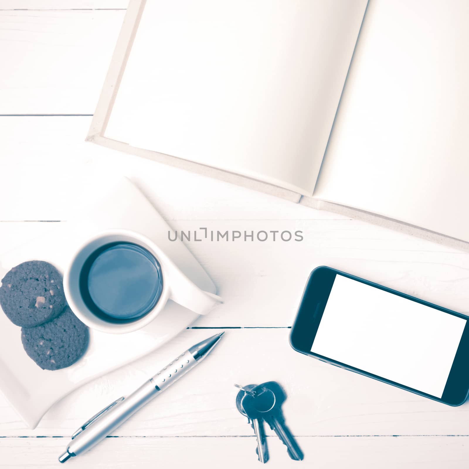 coffee cup with cookie,phone,notebook and key on white wood table vintage style