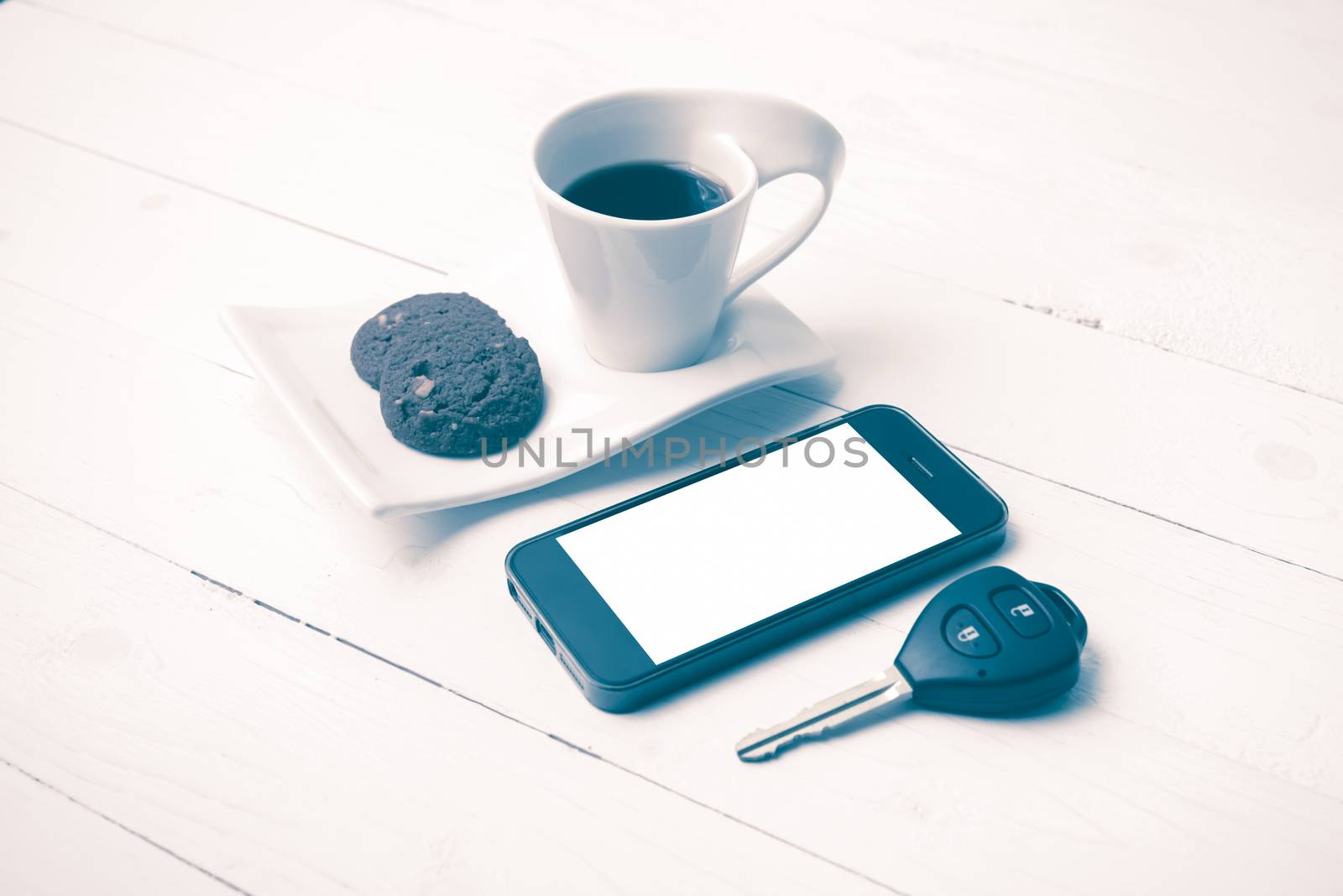 coffee cup with cookie,phone and car key on white wood table vintage style