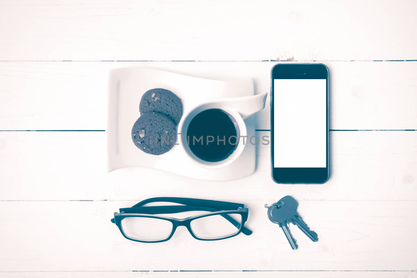 coffee cup with cookie,phone,eyeglasses and key on white wood background vintage style