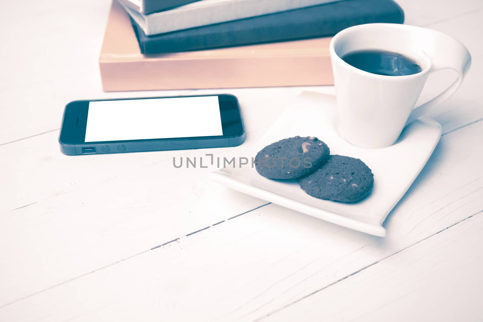 coffe cup with cookie,phone and stack of book on white wood table vintage style
