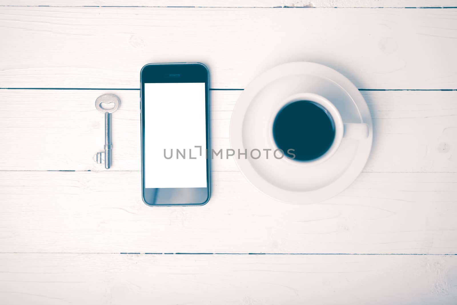 coffee cup with phone and key on white wood table vintage style
