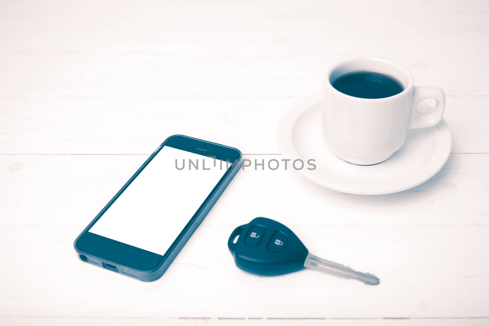 coffee cup with phone and car key on white wood table vintage style
