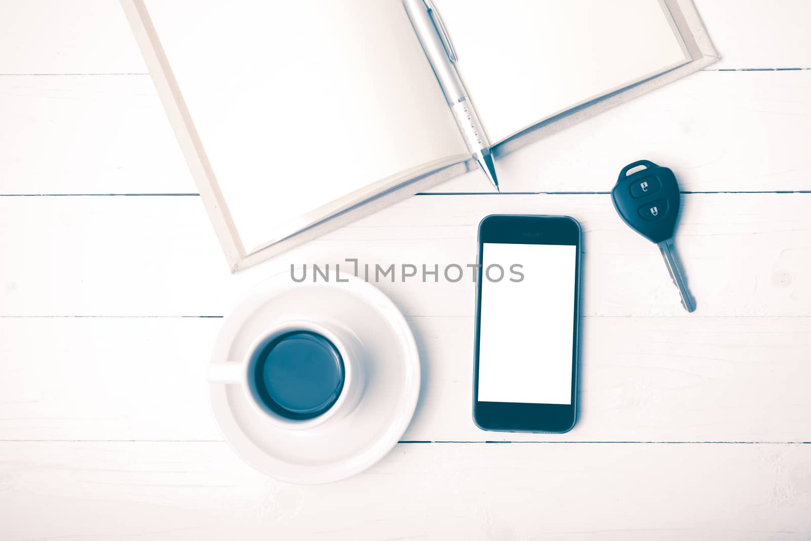 coffee cup with phone,car key and open notebook on white wood table vintage style