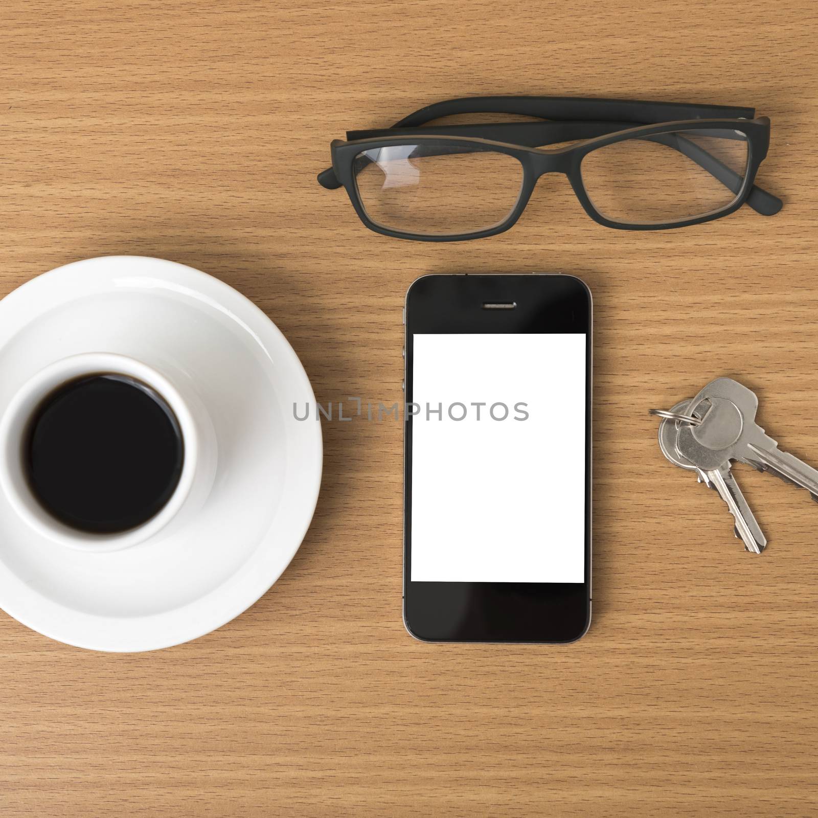 coffee cup and phone with key on wood background