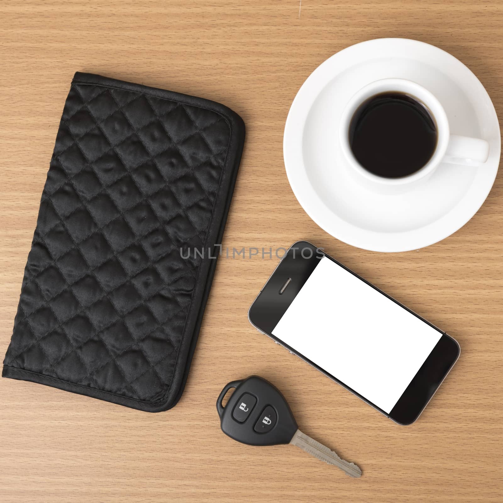 coffee cup with phone car key and wallet on wood background