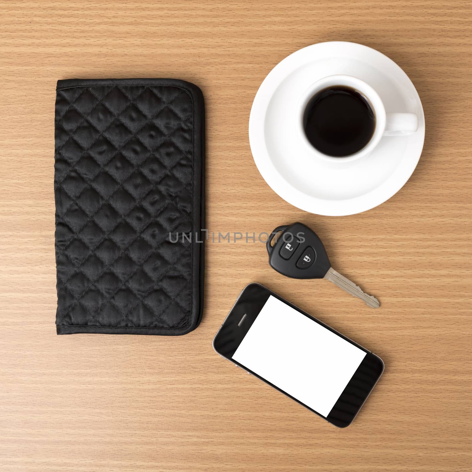 coffee cup with phone car key and wallet on wood background