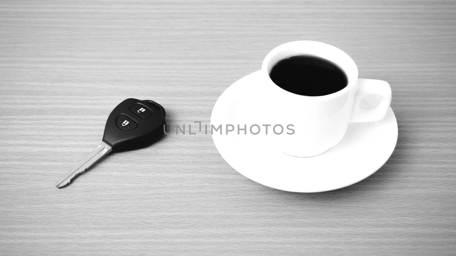 coffee cup and car key on wood background  black and white color