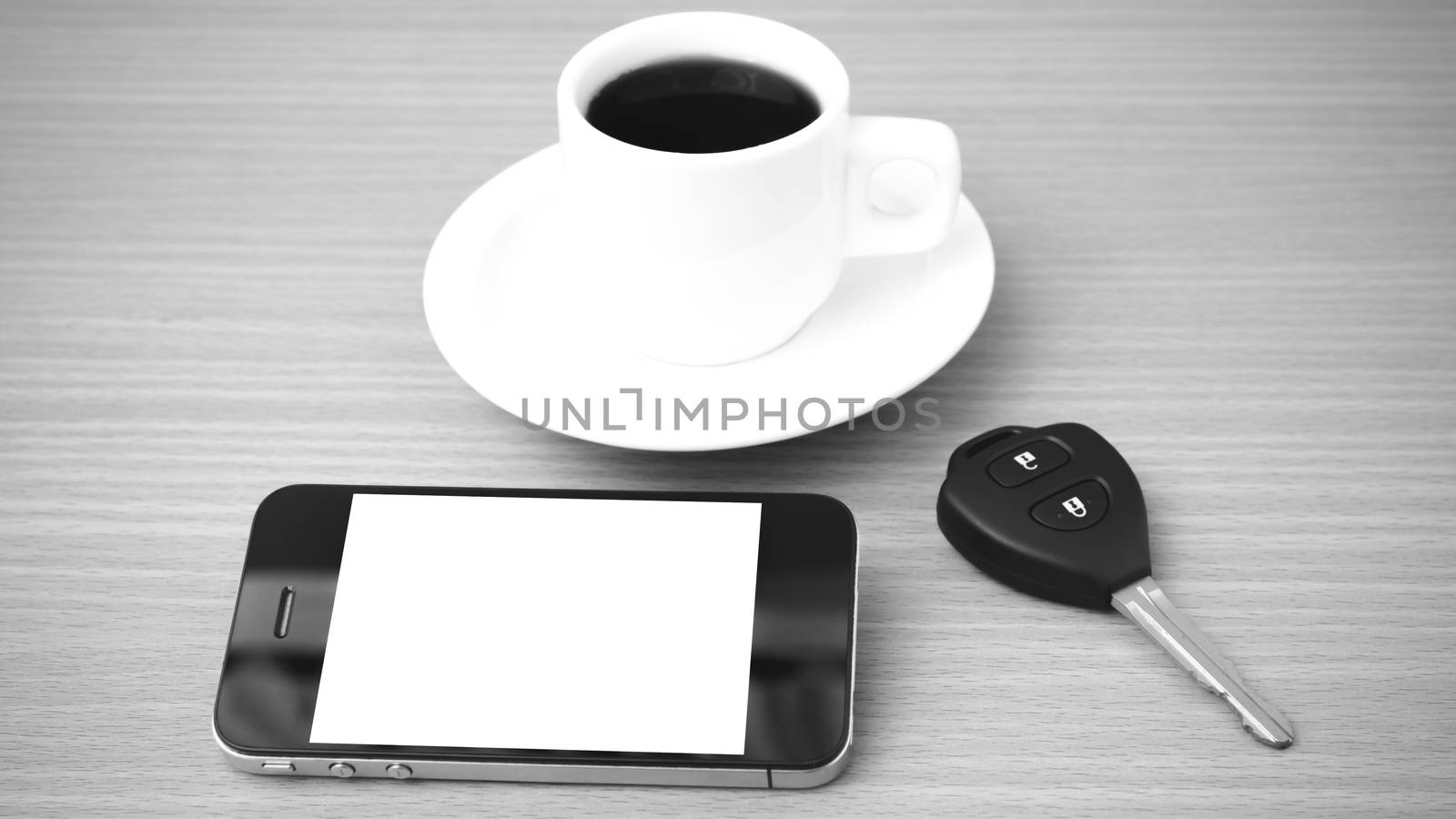 coffee cup and phone and car key on wood background black and white color