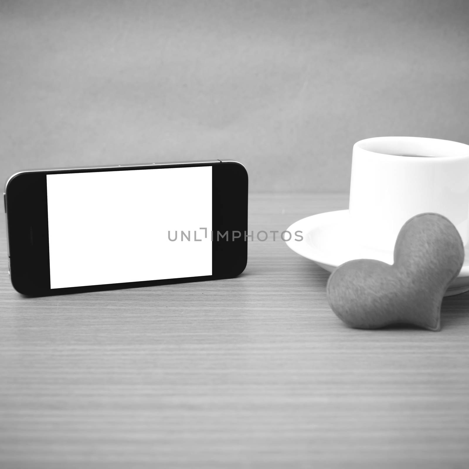 coffee cup and phone and heart on wood background black and white color
