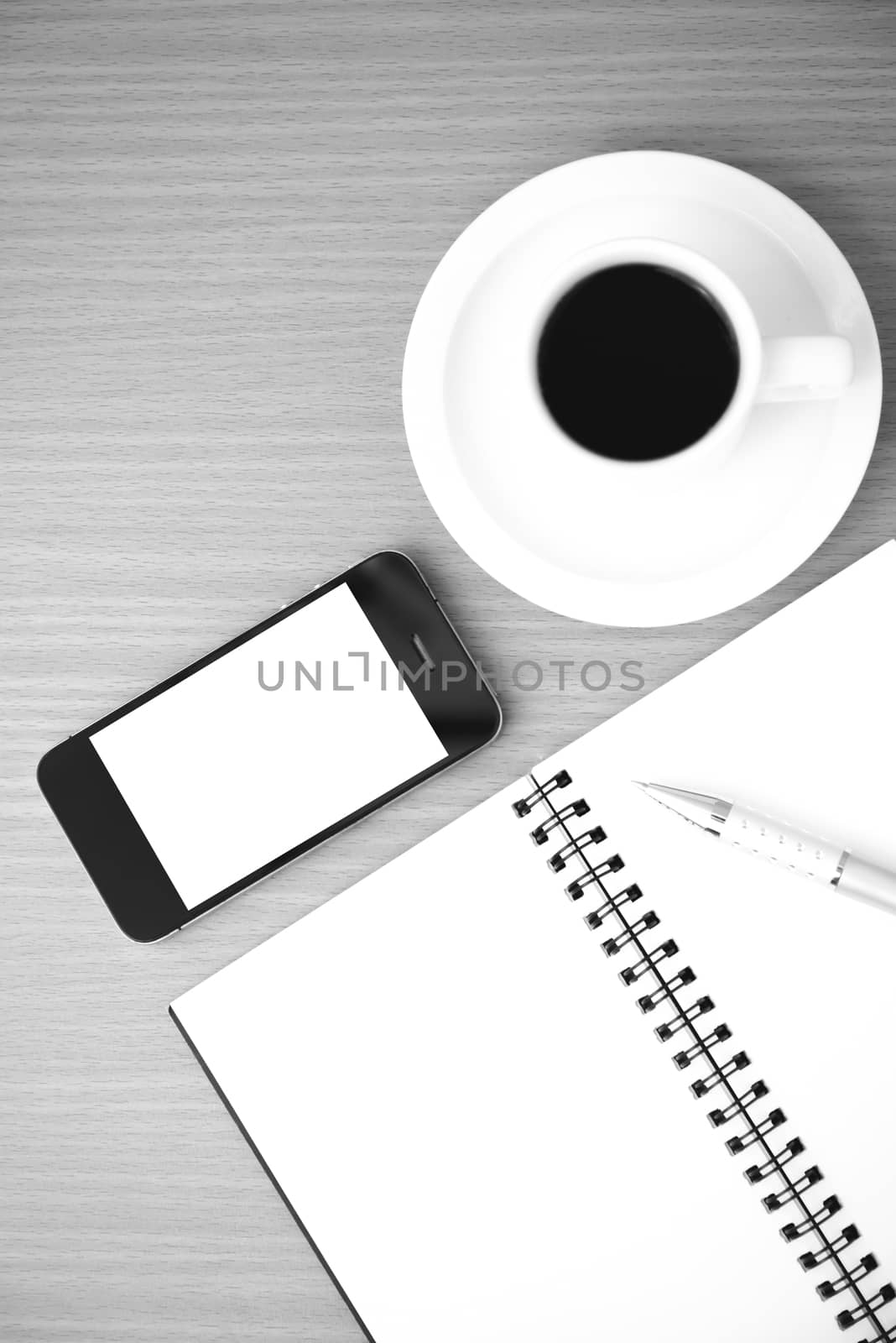 coffee cup and phone and notepad on wood background  black and white color