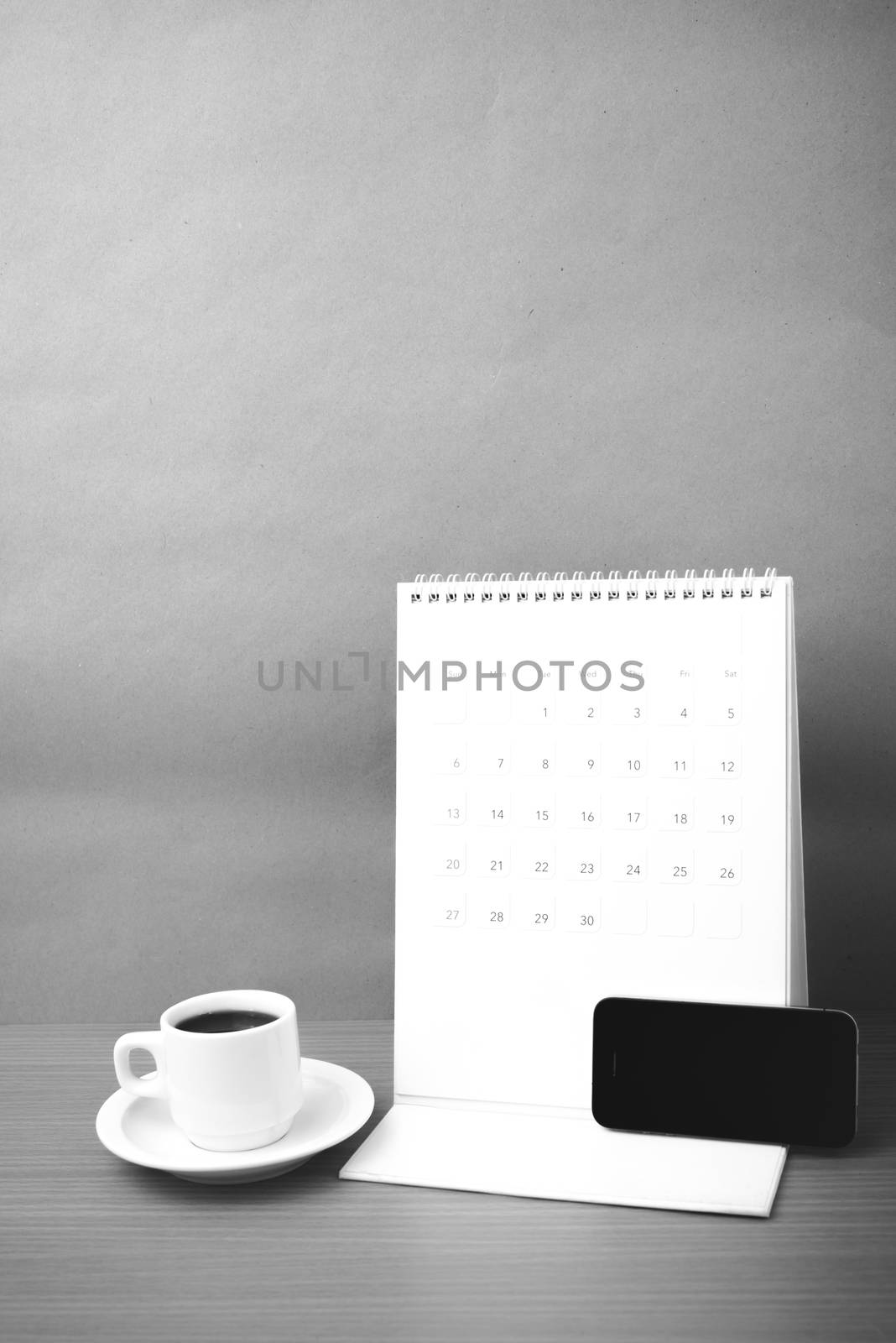 coffee cup and phone and calendar on wood background  black and white color