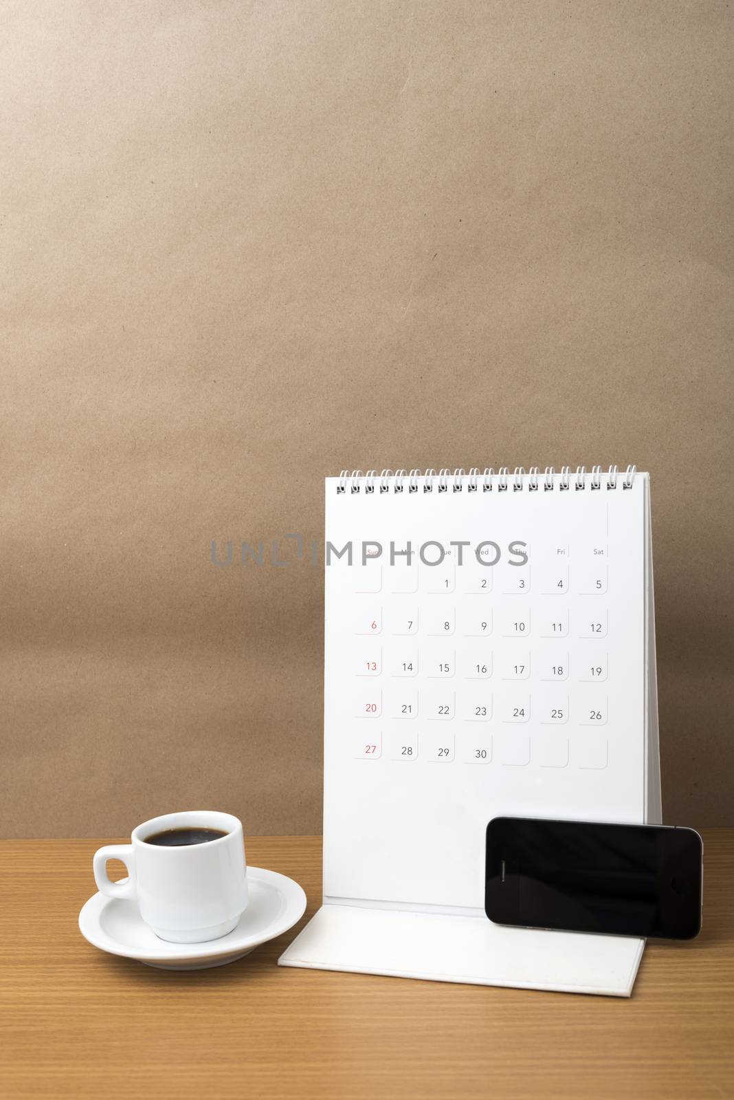 coffee cup and phone and calendar on wood background