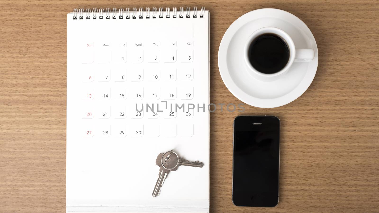 coffee,phone,key and calendar on wood table background