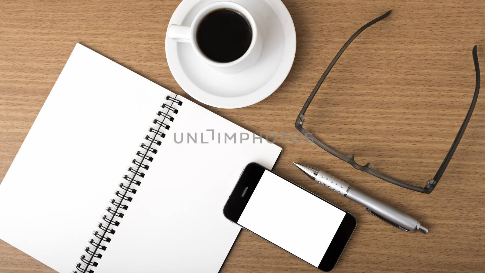 coffee,phone,notepad and eyeglasses on wood table background