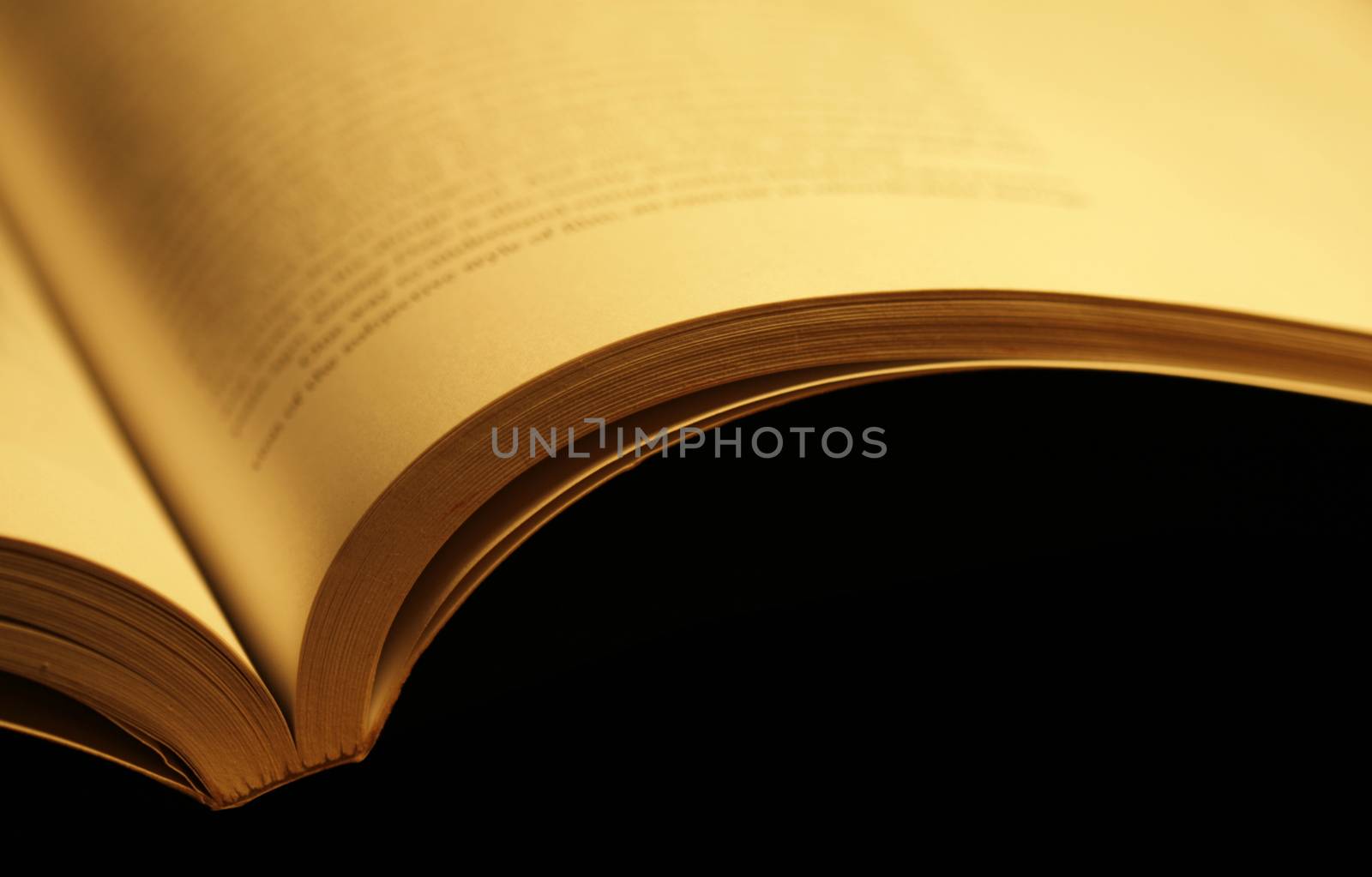 Horizontal photo of an old open book on black background
