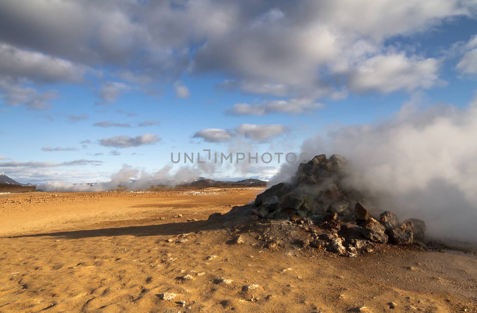 Horizontal view of steam hot springs coming out of the ground in the volcanic valley near Myvatn baths in Iceland