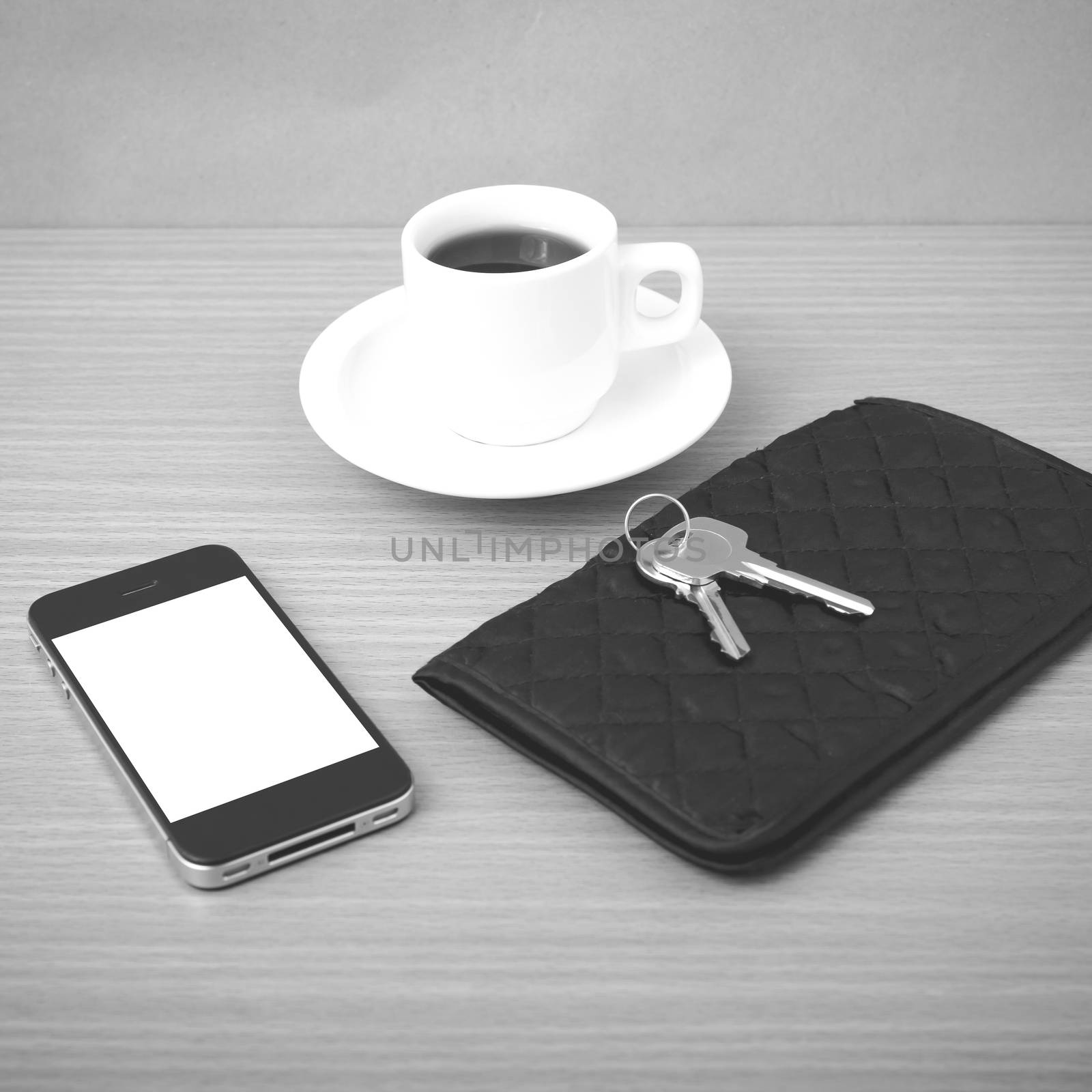 coffee phone key and wallet on wood table background black and white color