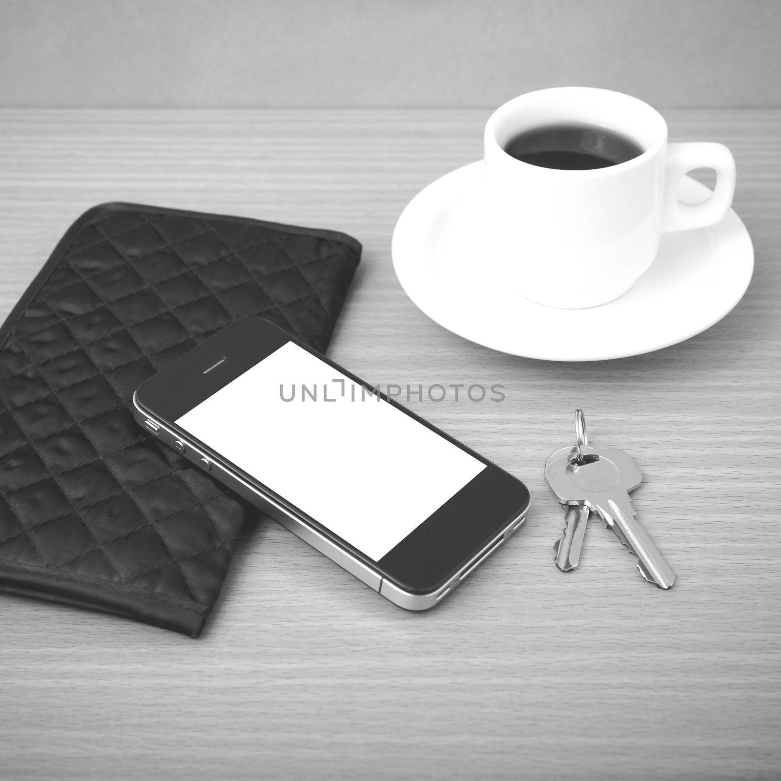 coffee phone key and wallet on wood table background black and white color