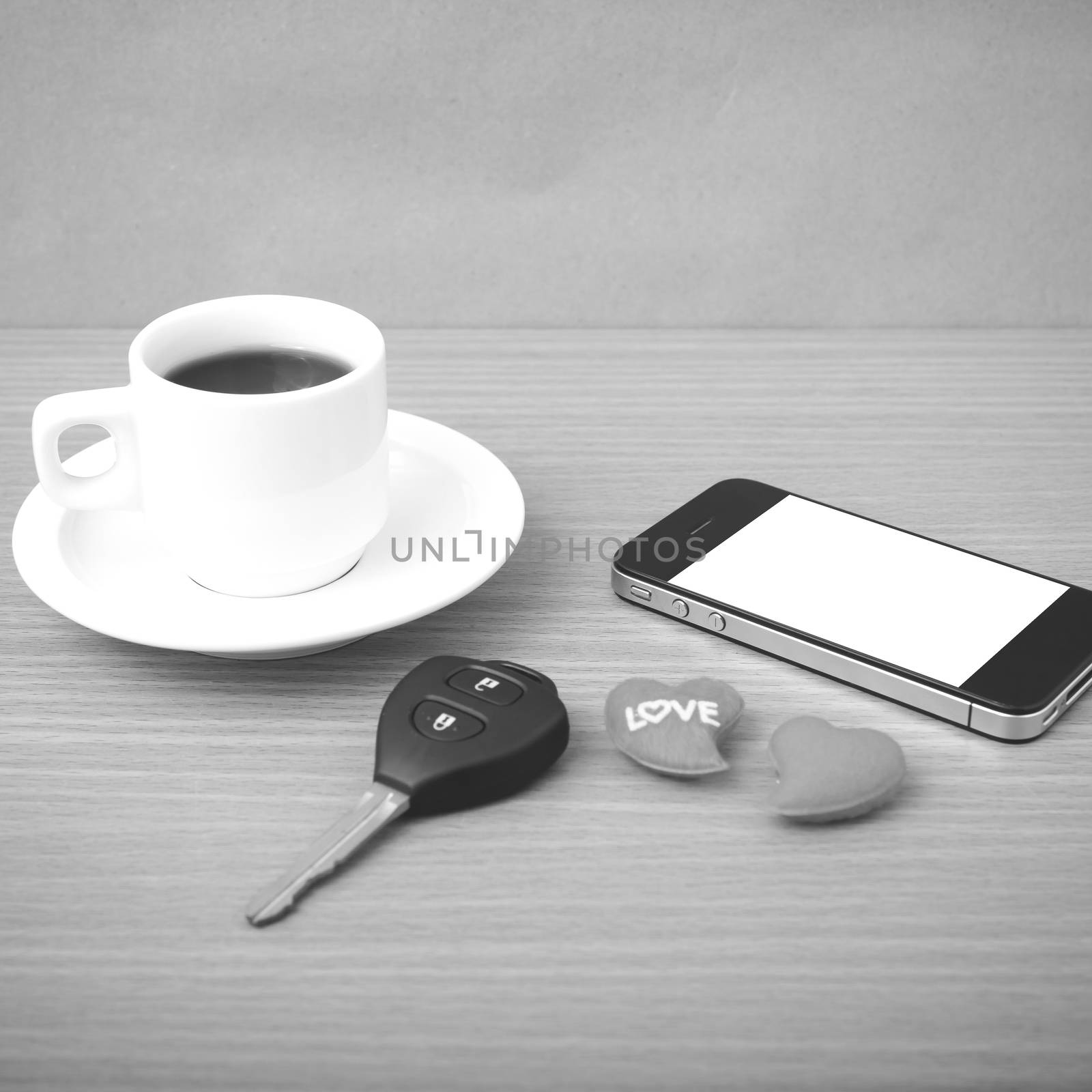 coffee phone car key and heart on wood table background black and white color