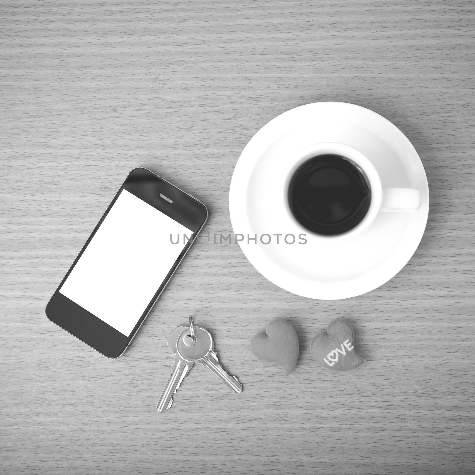 coffee phone key and heart on wood table background black and white color