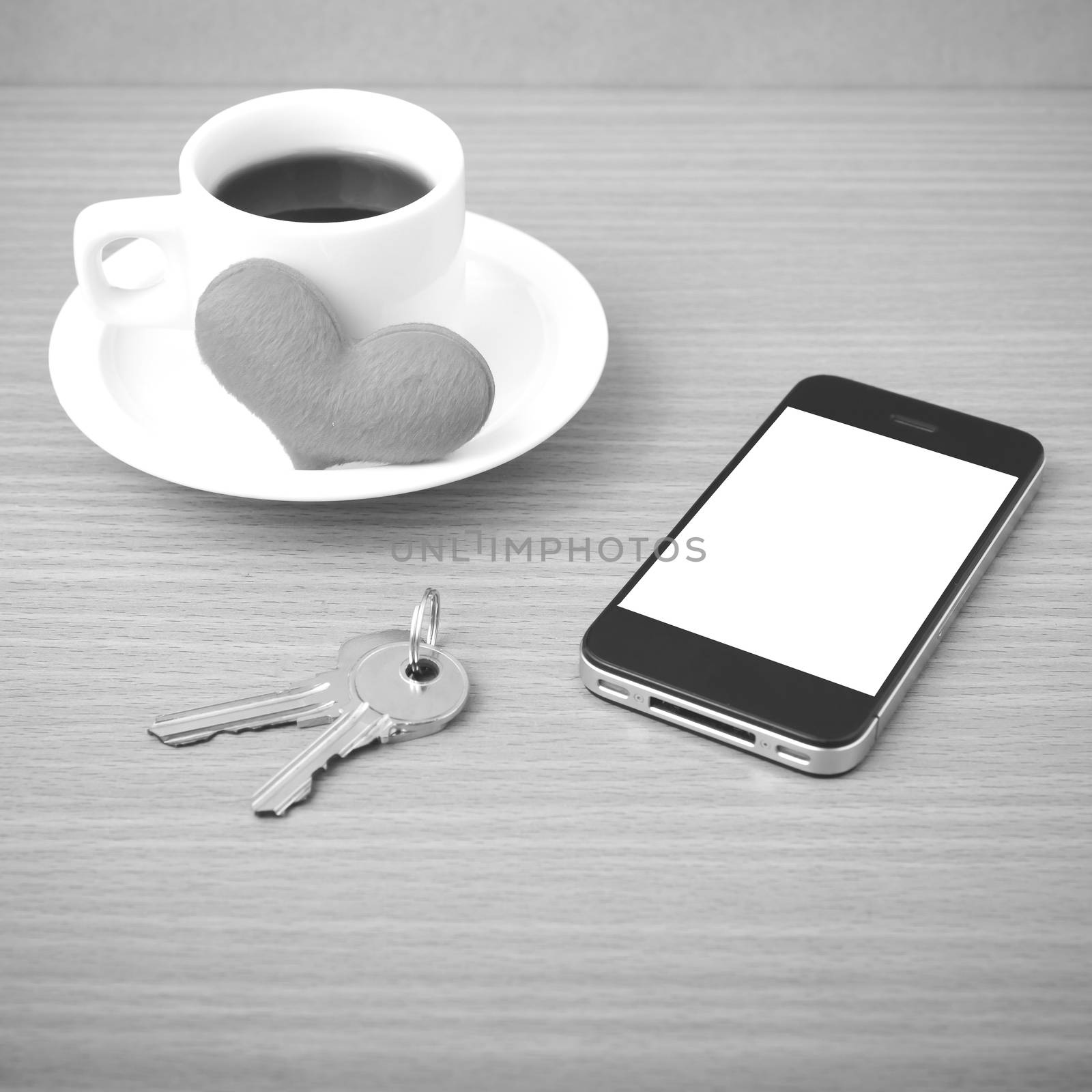 coffee phone key and heart on wood table background black and white color