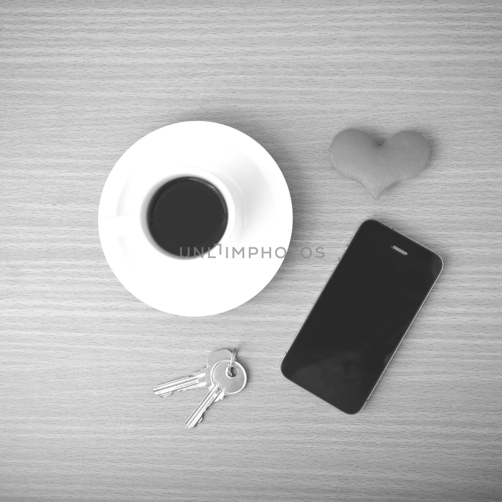 coffee phone key and heart on wood table background black and white color