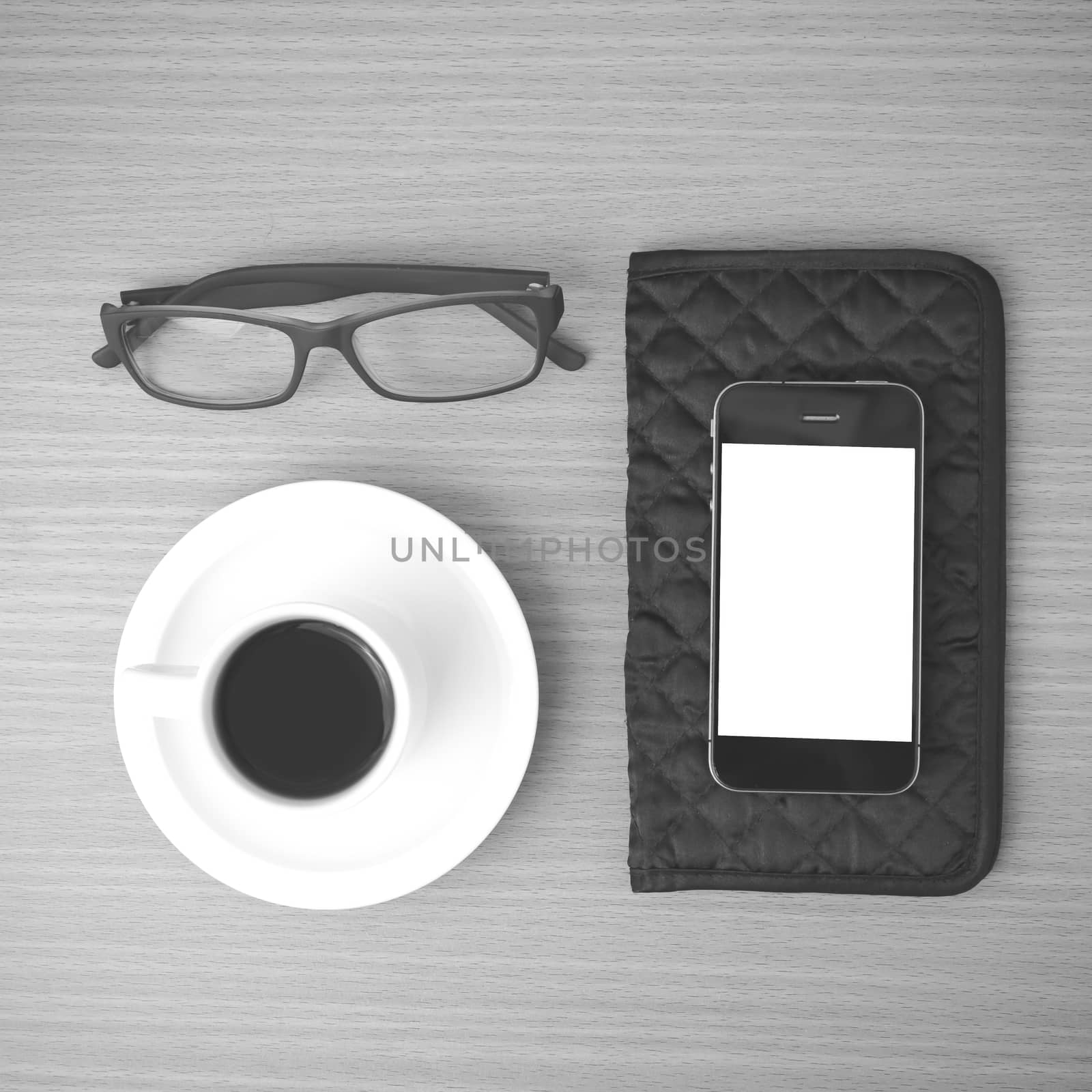 coffee,phone,eyeglasses and wallet on wood table background black and white color