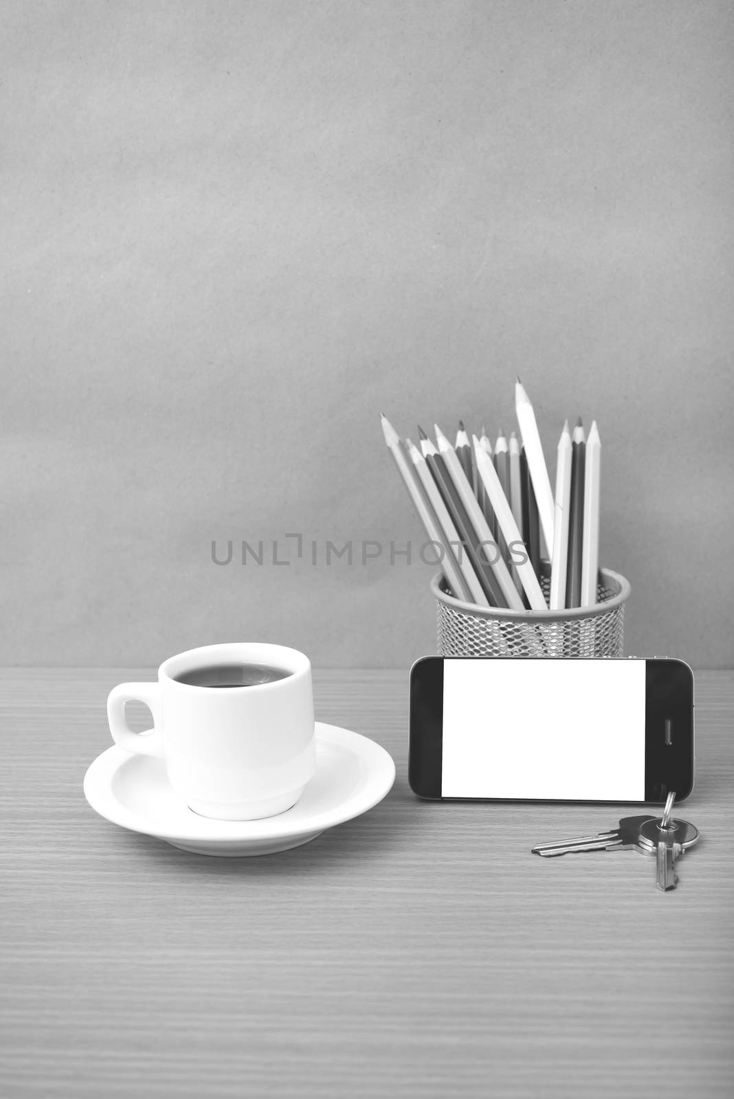 coffee,phone,key and pencil on wood table background black and white color