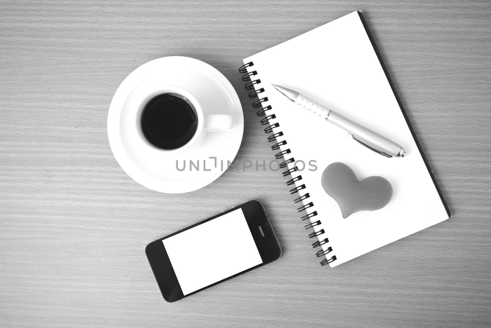 coffee,phone,notepad and heart on wood table background black  and white color