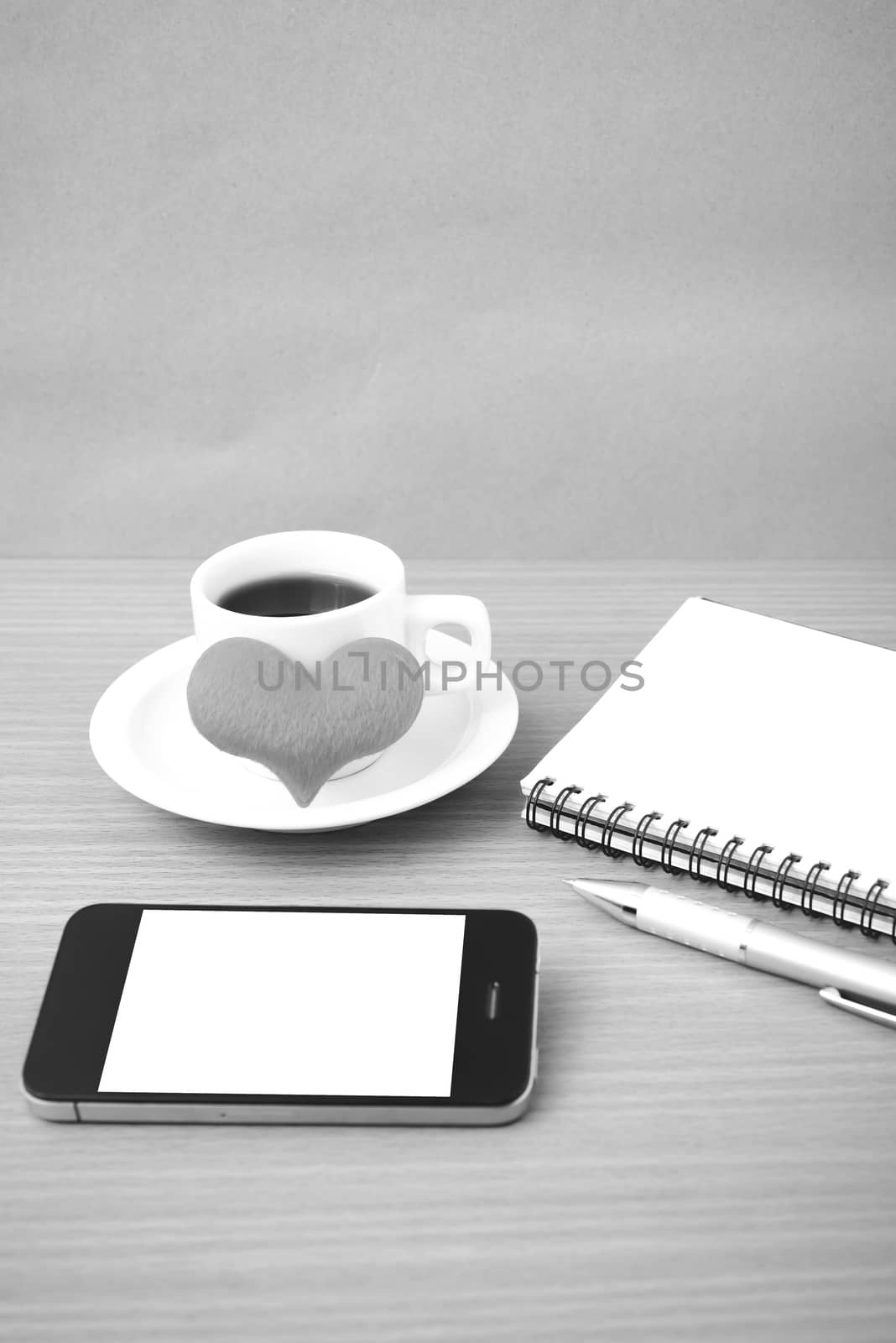 coffee,phone,notepad and heart on wood table background black  and white color