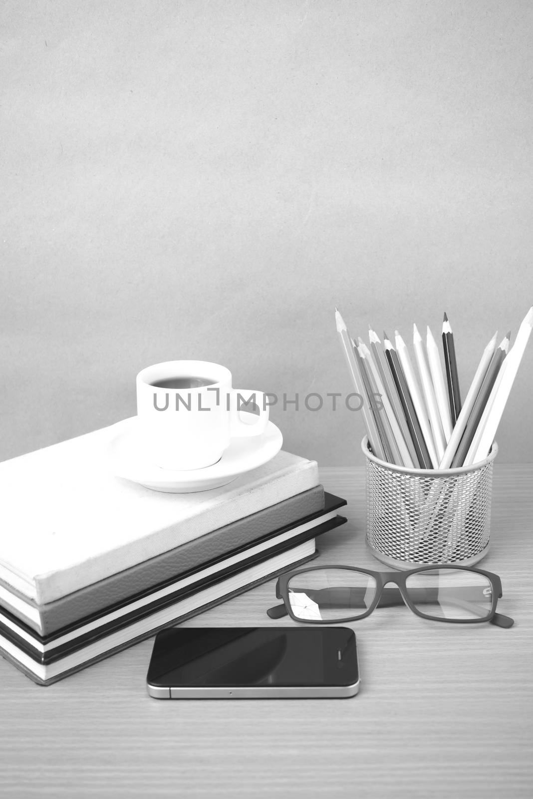 coffee,phone,eyeglasses,stack of book and color pencil on wood table background  black  and white color