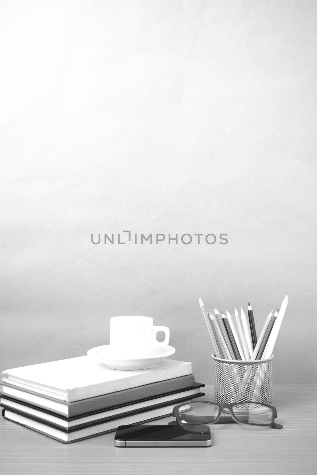 coffee,phone,eyeglasses,stack of book and color pencil on wood table background  black  and white color