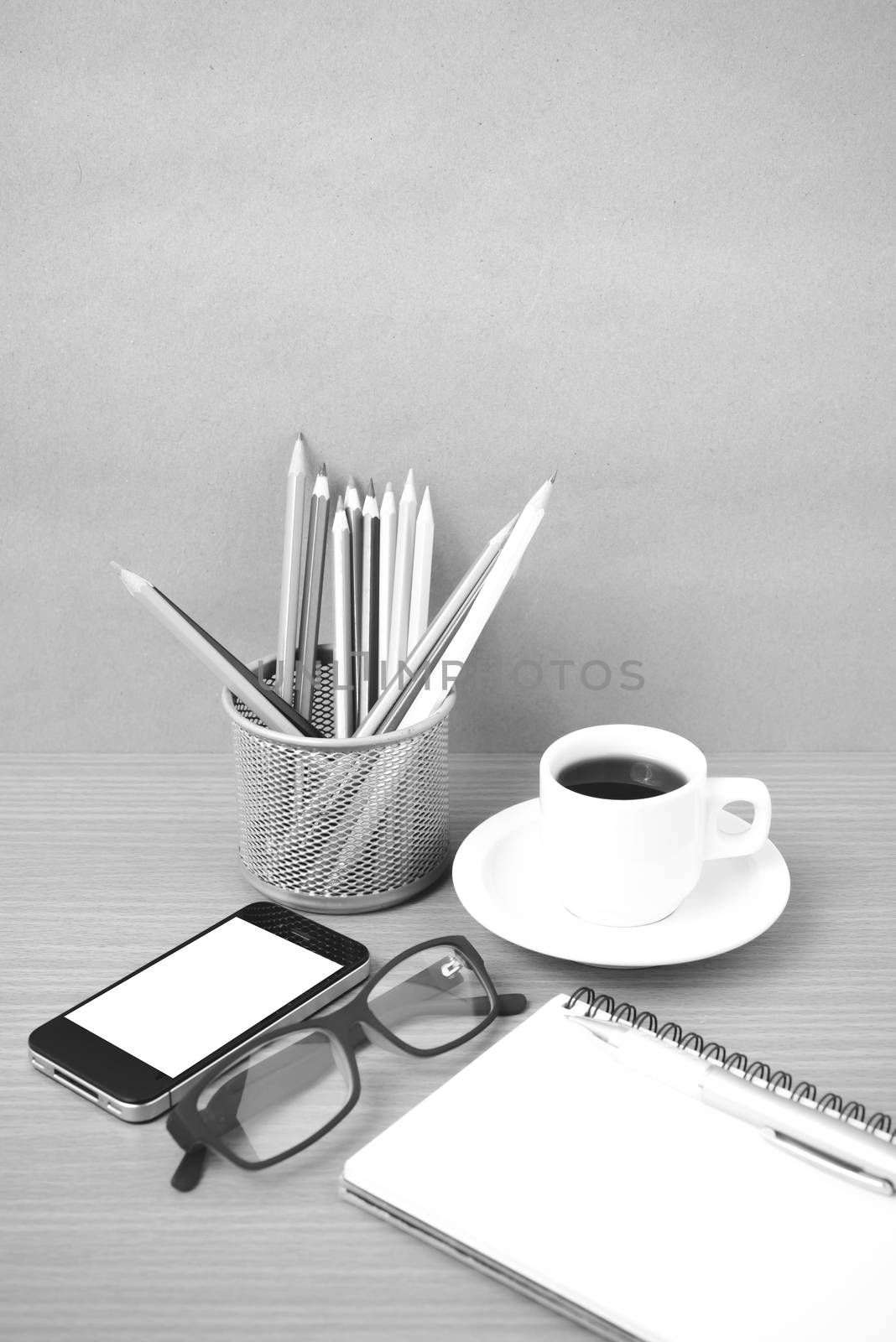 coffee,phone,eyeglasses,notepad and color pencil on wood table background black  and white color