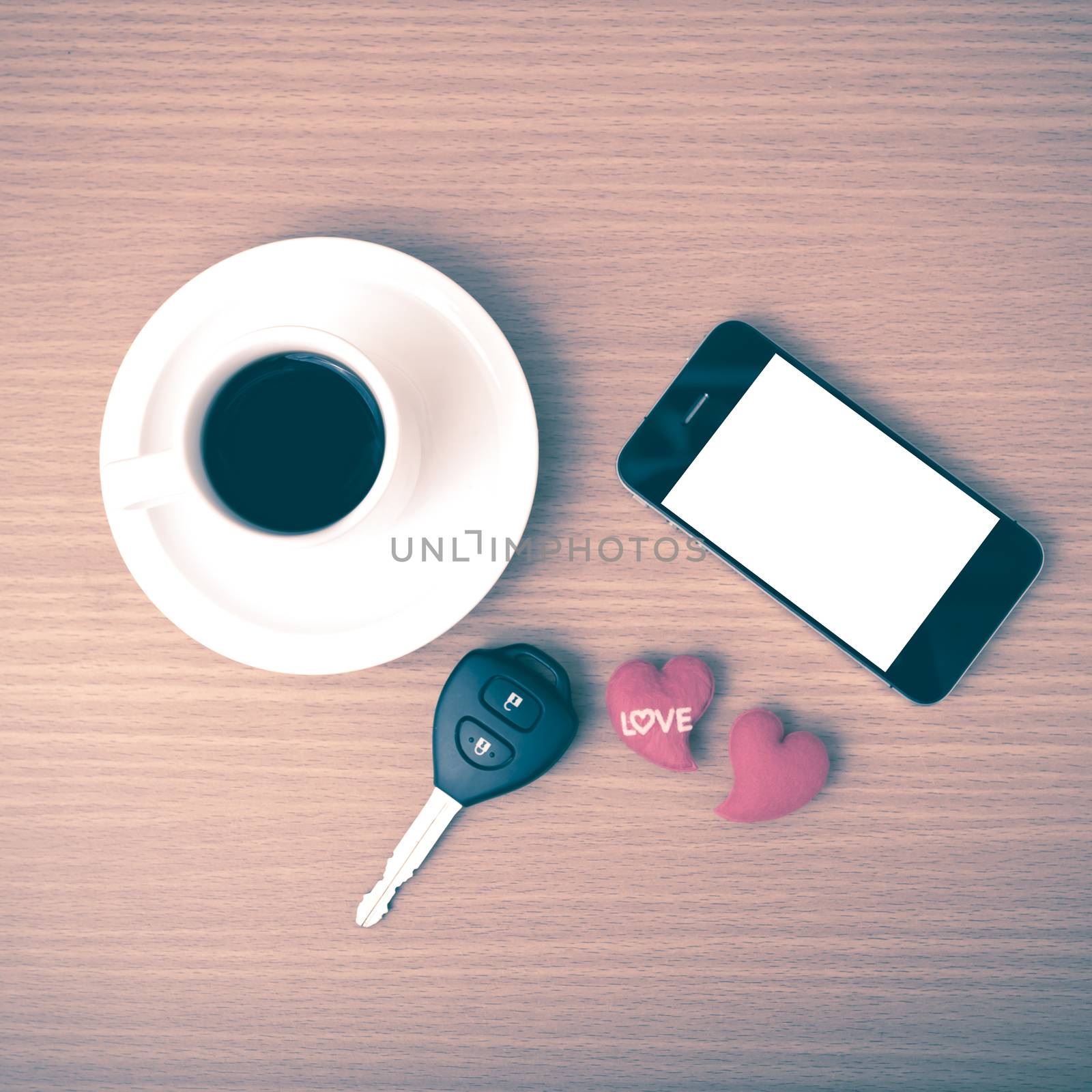 coffee phone car key and heart on wood table background vintage style