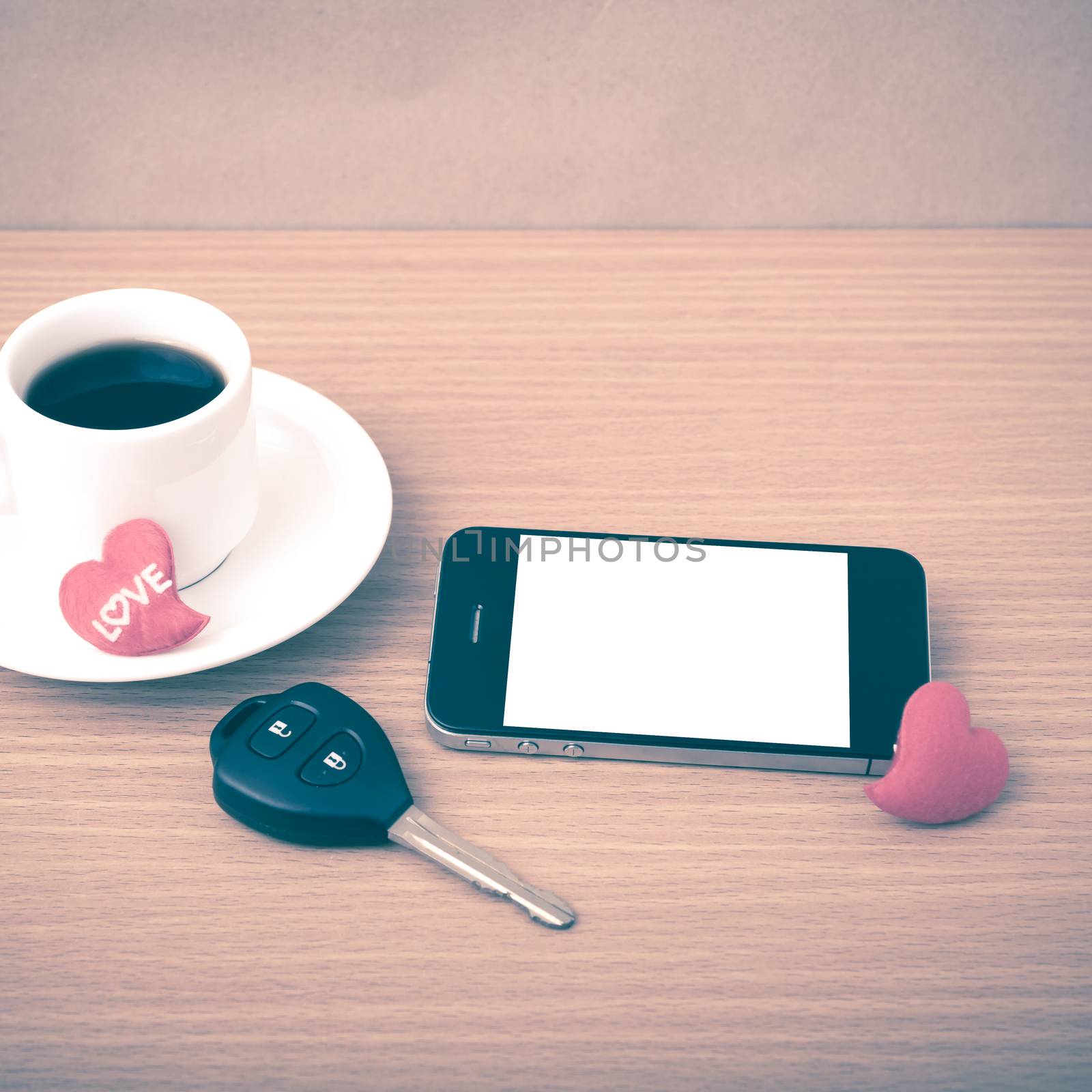coffee phone car key and heart on wood table background vintage style
