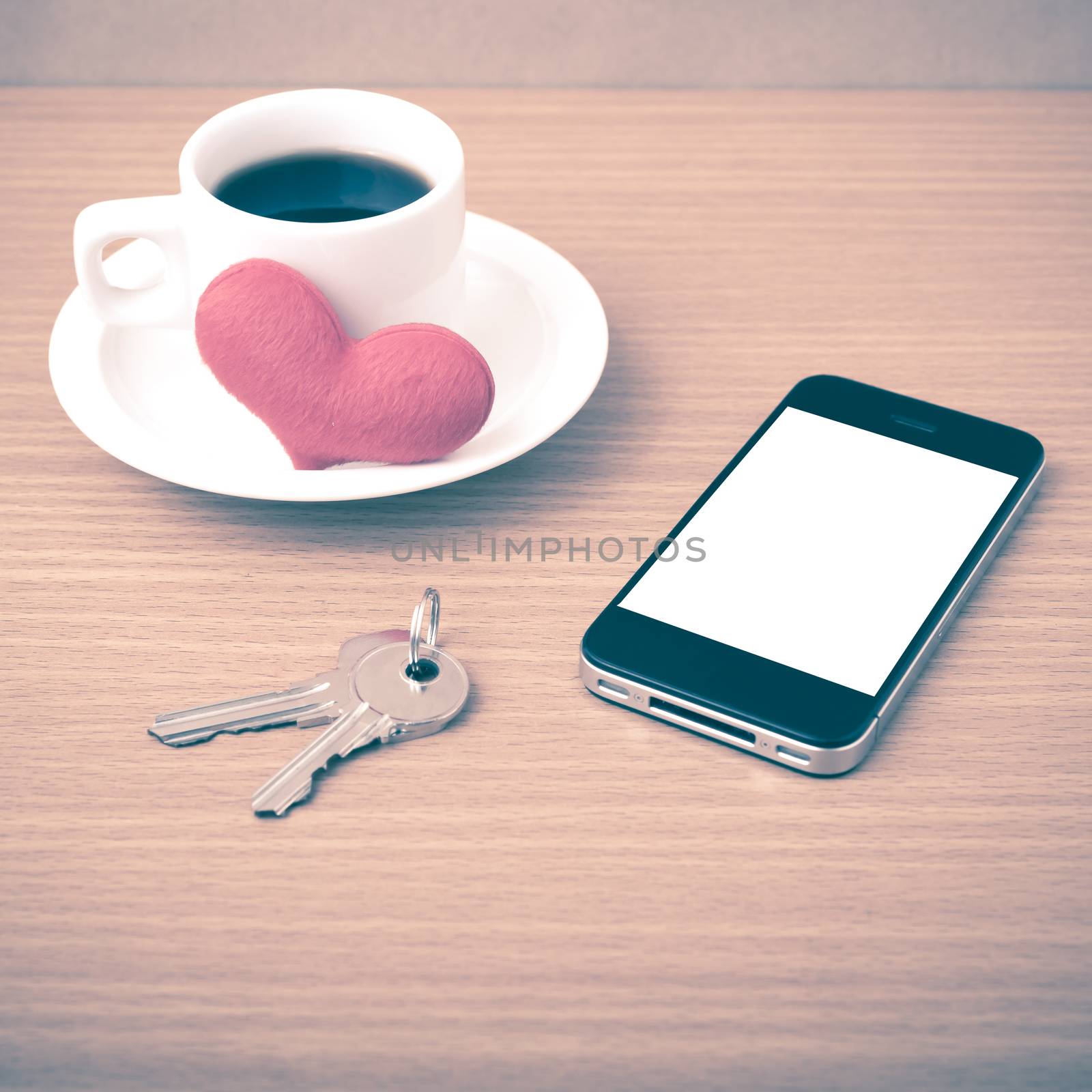 coffee phone key and heart on wood table background vintage style