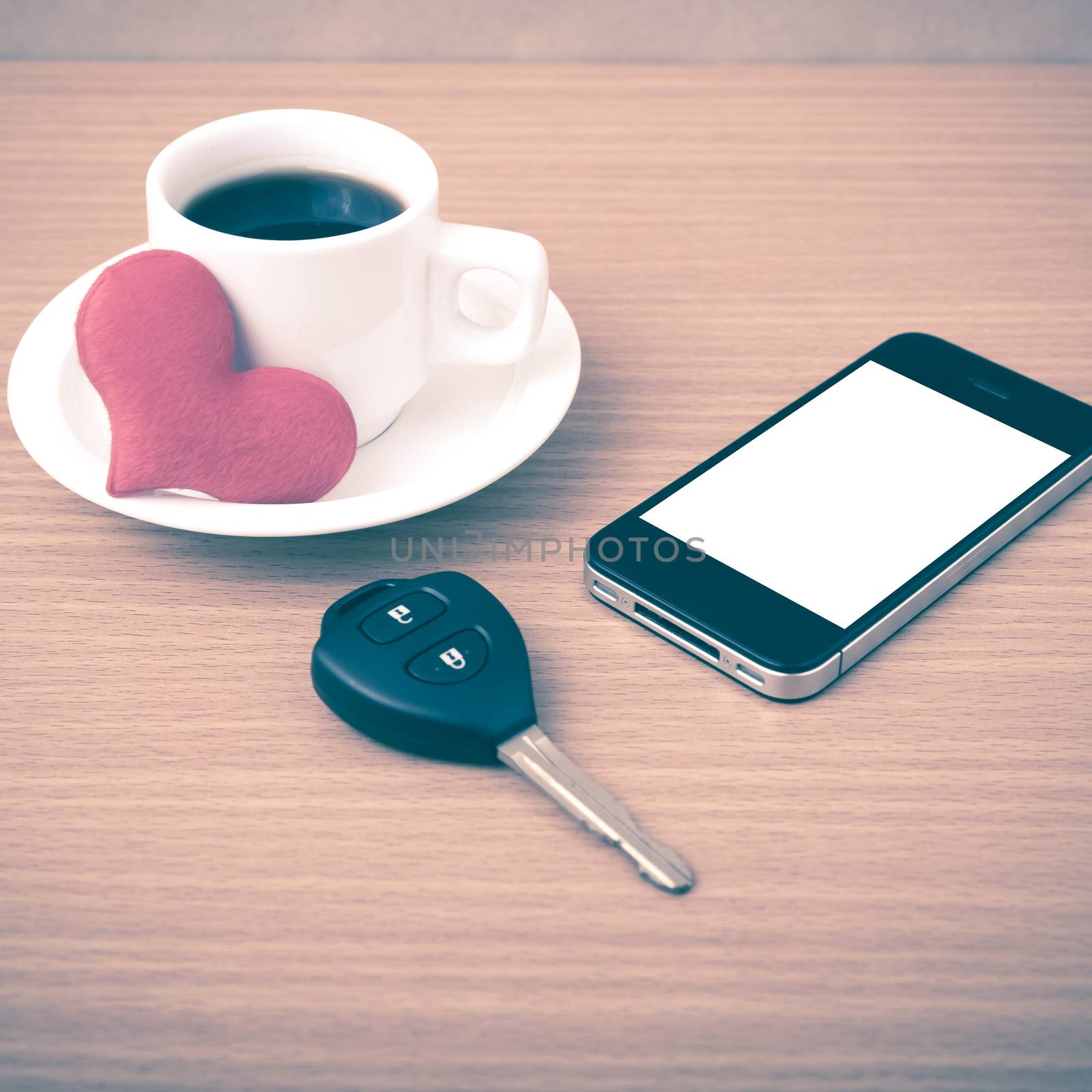 coffee phone car key and heart on wood table background vintage style