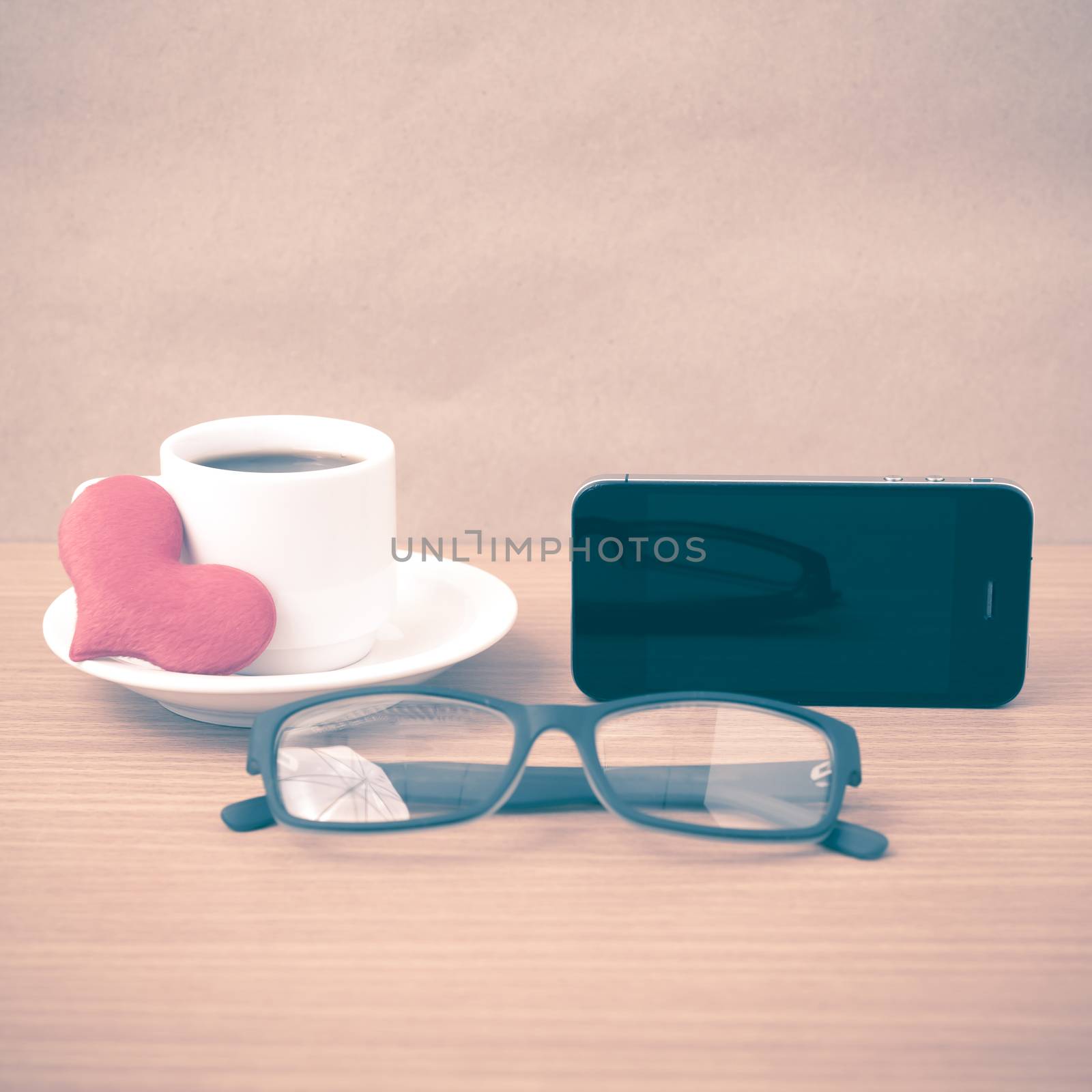 coffee,phone,eyeglasses and heart on wood table background vintage style