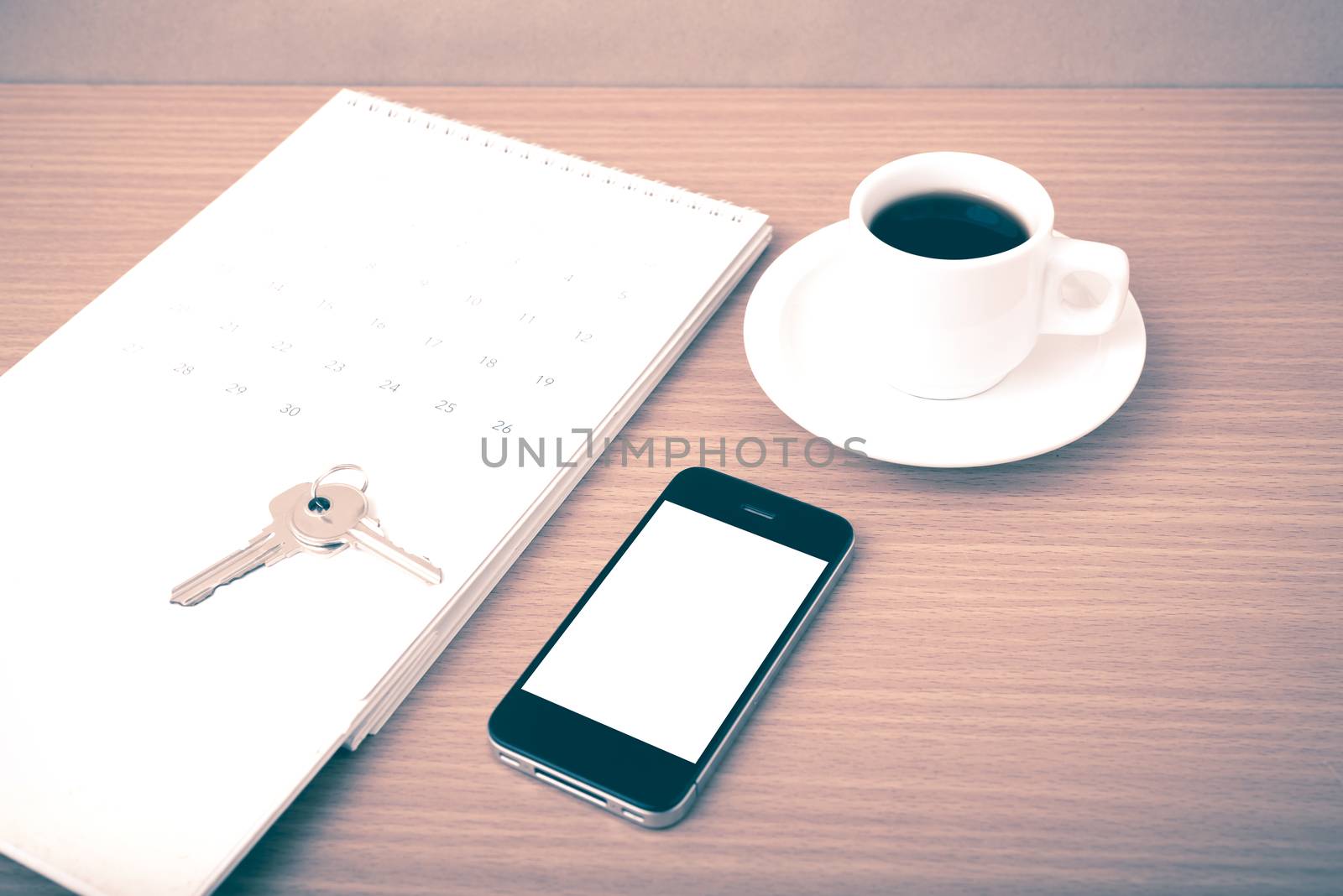 coffee,phone,key and calendar on wood table background vintage style