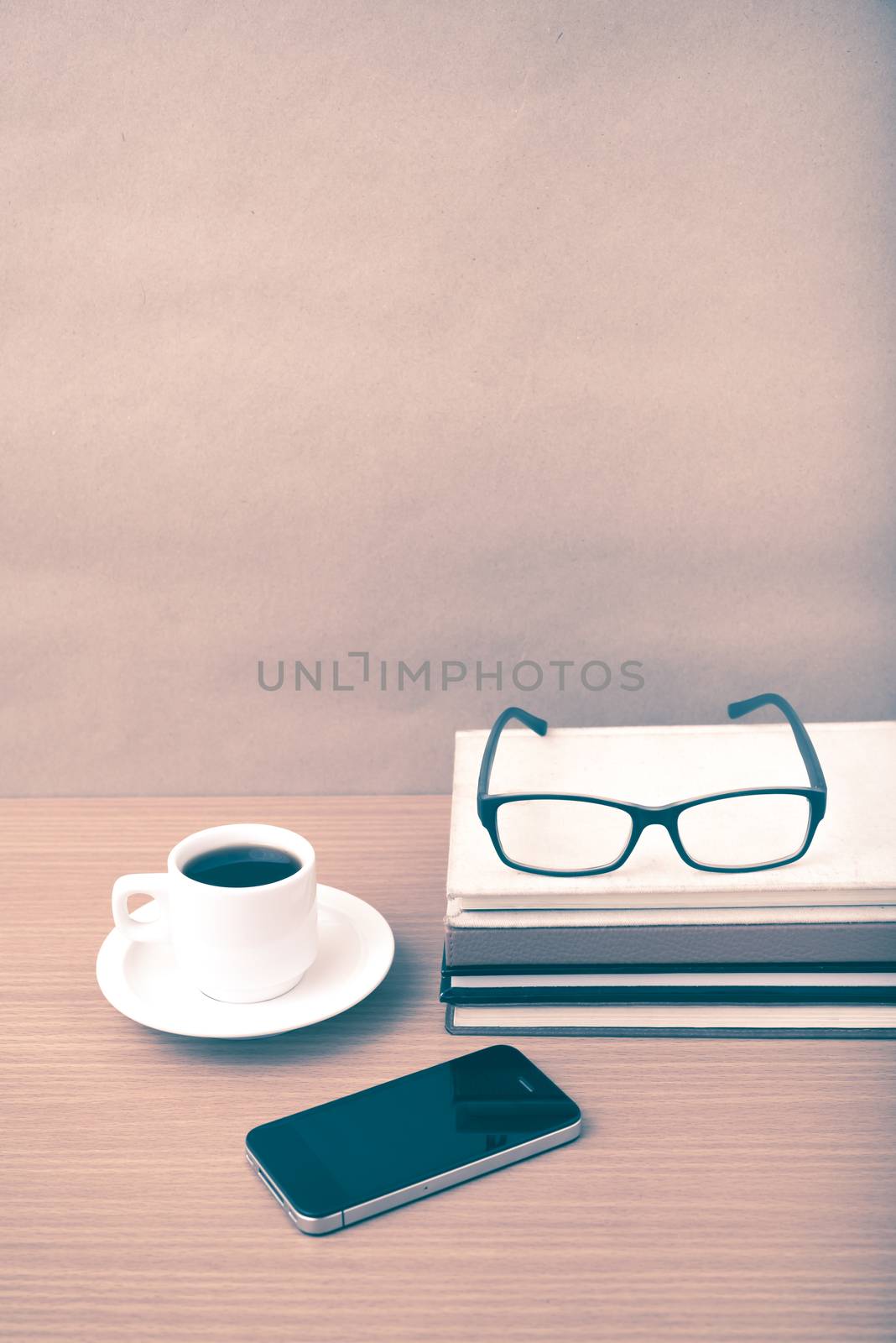 coffee,phone,stack of book and eyeglasses on wood table background vintage style