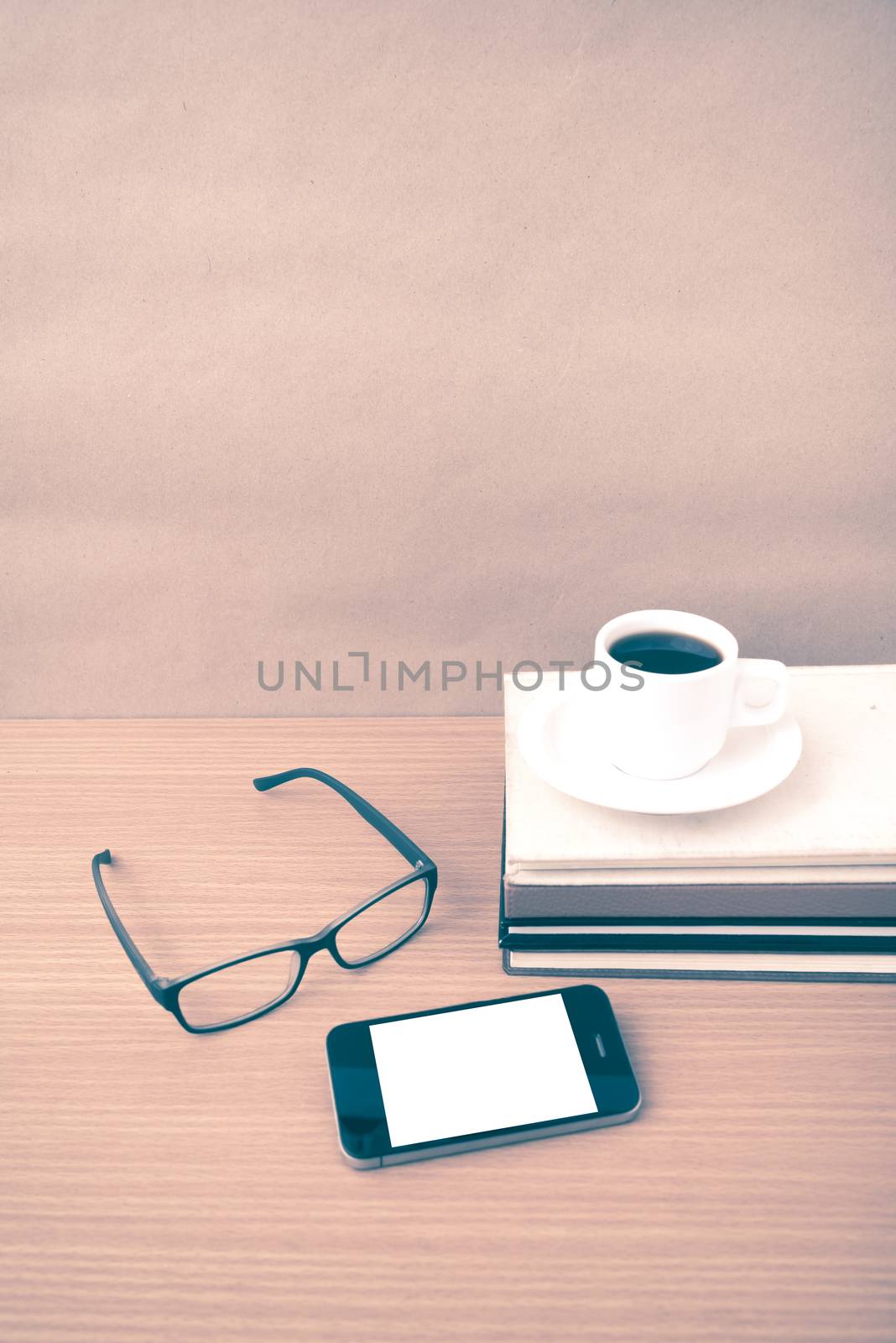 coffee,phone,stack of book and eyeglasses on wood table background vintage style