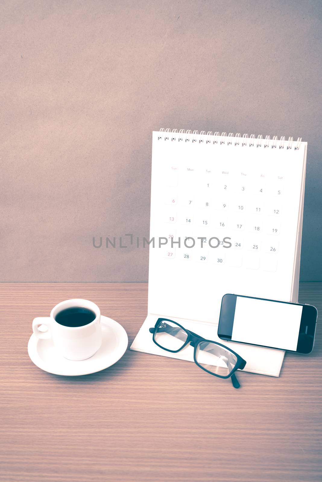 coffee,phone,eyeglasses and calendar on wood table background vintage style