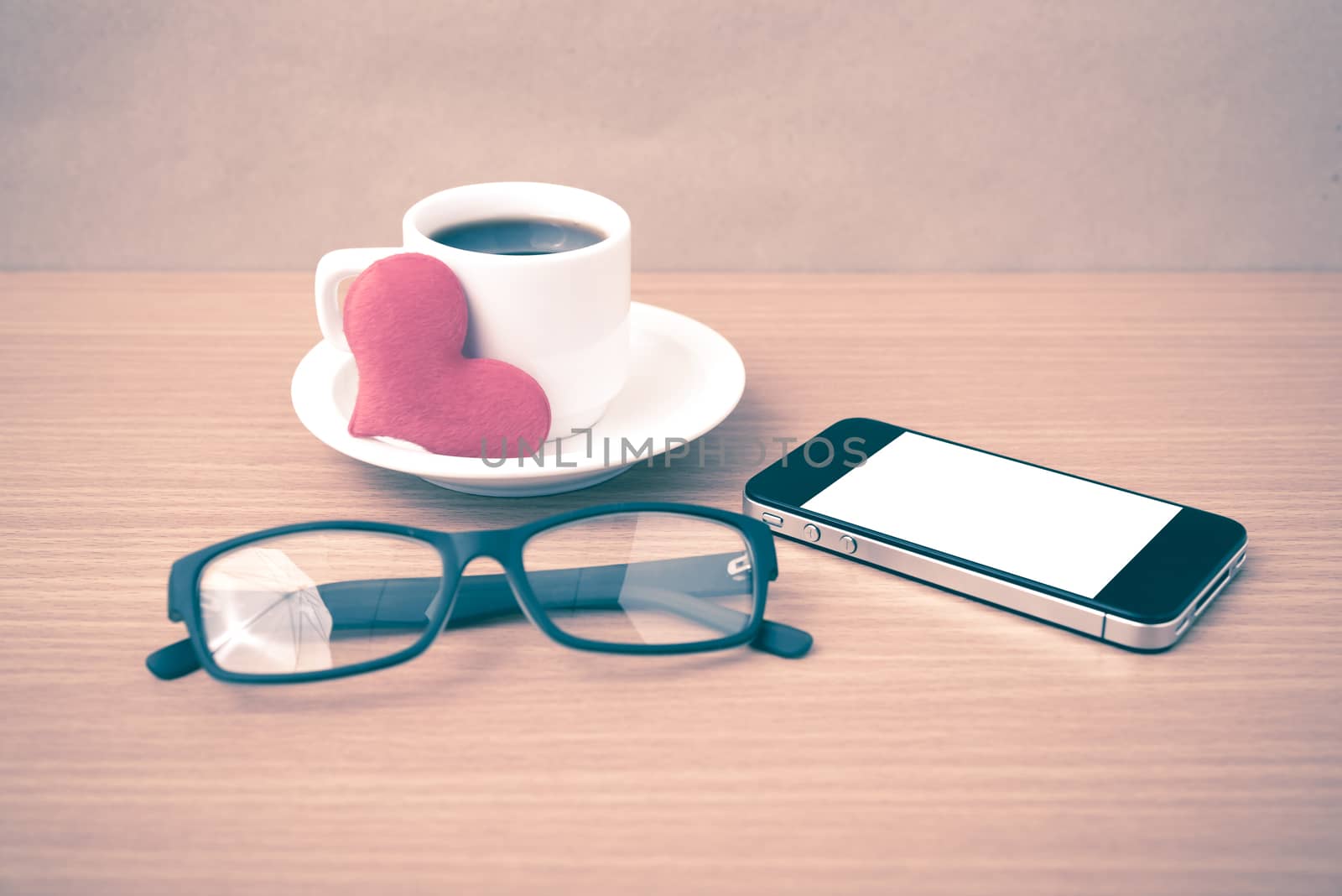 coffee,phone,eyeglasses and heart on wood table background vintage style