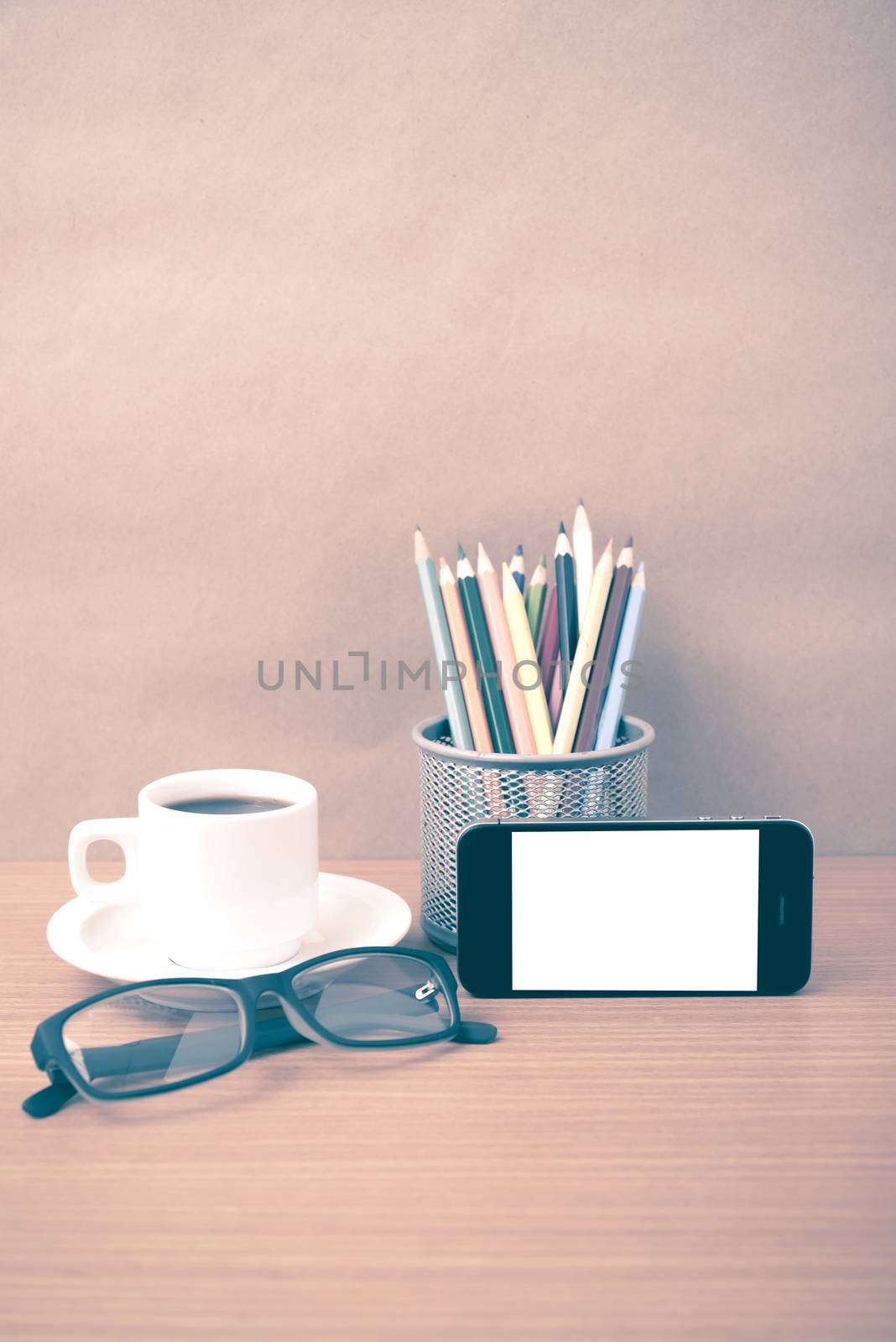 coffee,phone,eyeglasses and pencil on wood table background vintage style