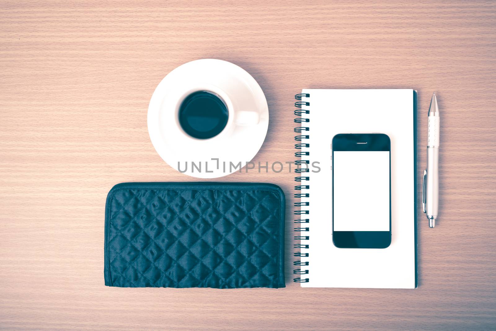 coffee,phone,notepad and wallet on wood table background vintage style