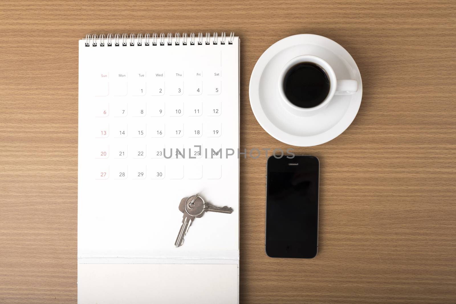 coffee,phone,key and calendar on wood table background