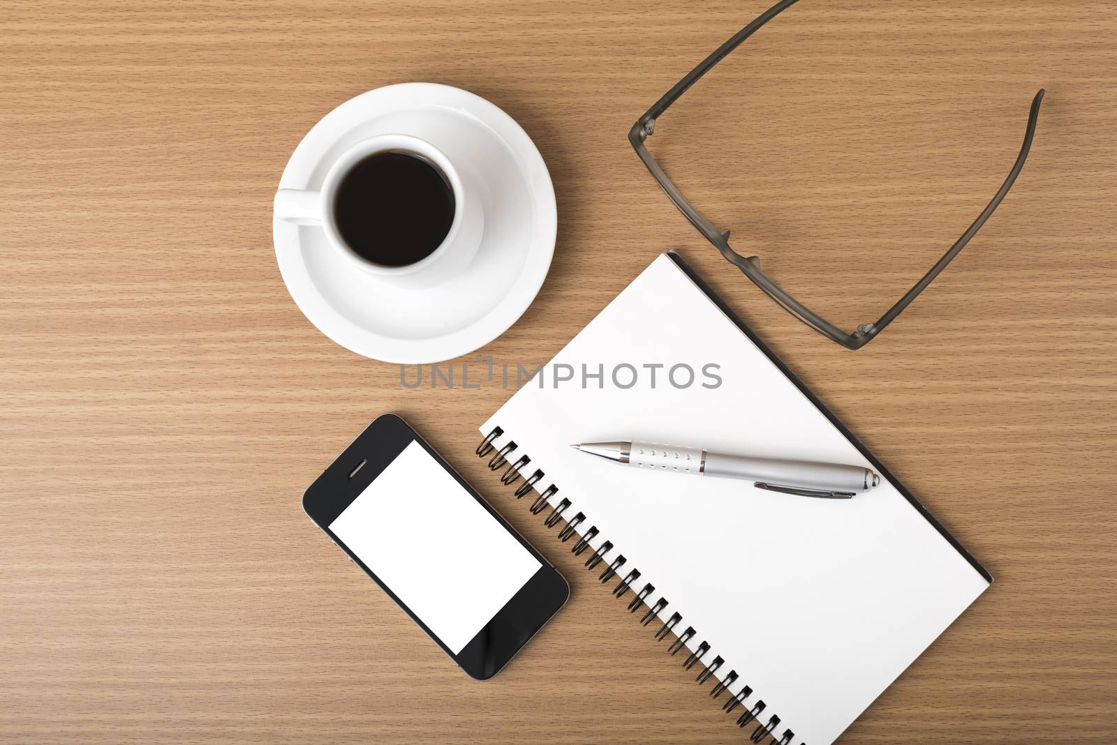 coffee,phone,notepad and eyeglasses on wood table background