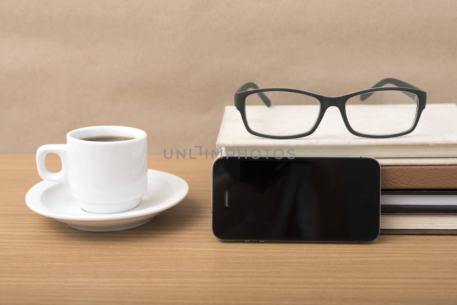 coffee,phone,stack of book and eyeglasses on wood table background