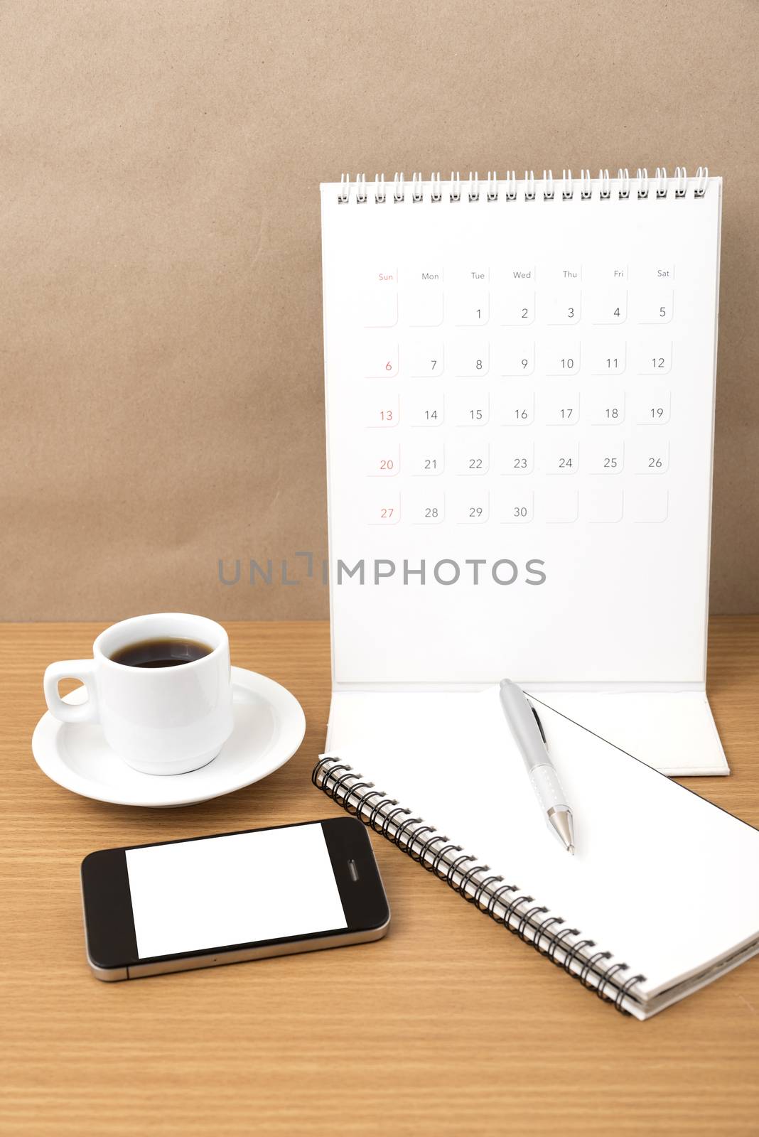 coffee,phone,notepad and calendar on wood table background